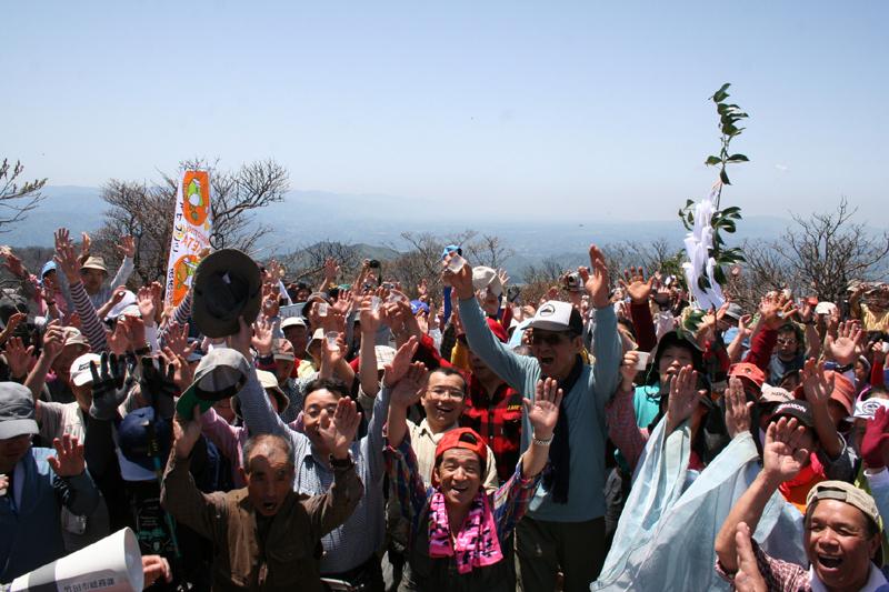 祖母山山開きの参加者達がカメラに向かって手を上げている写真